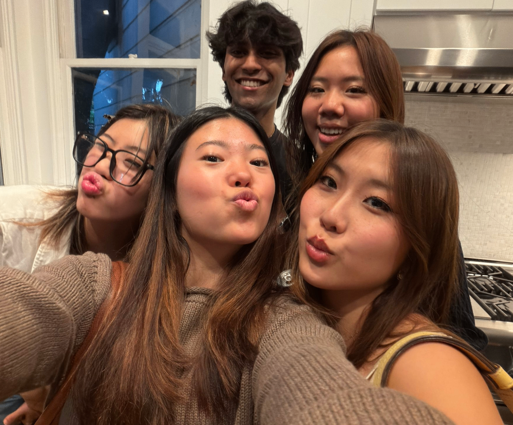 Friends making faces in a kitchen selfie